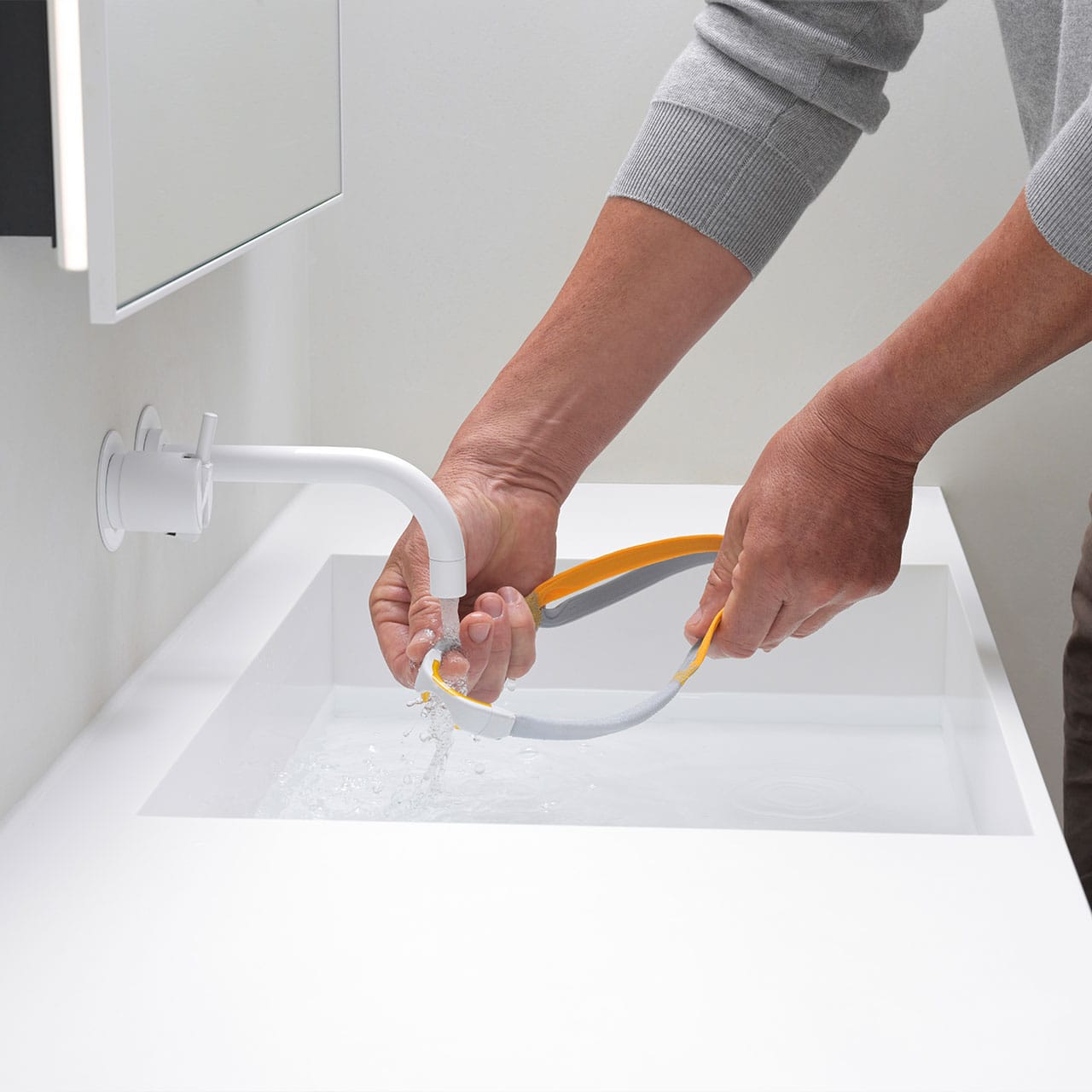 Hands rinsing the F&P Solo Mask under a running tap